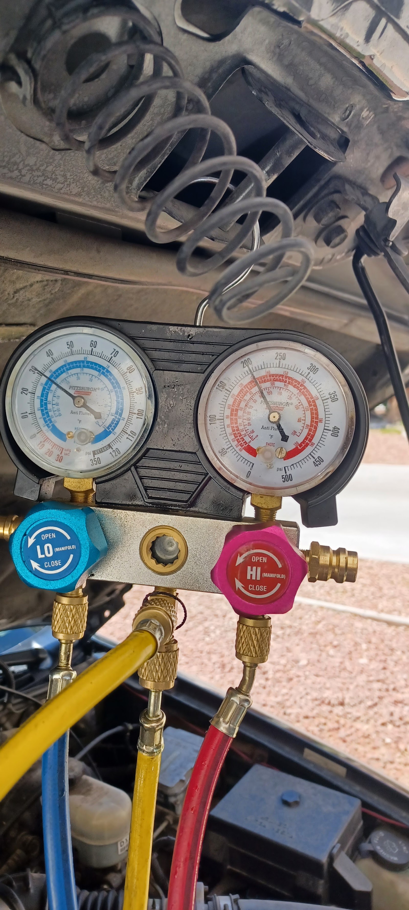 AC manifold gauge set connected during automotive air conditioning service